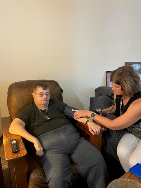 SDHD staff member taking the blood pressure of a man sitting in a recliner