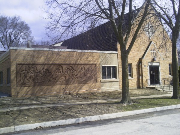 Brick church with frees in front without leaves